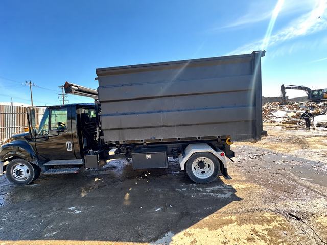 Roll-off bin truck loaded for debris haul-away