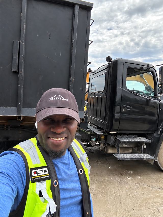 Crew member in a CSD safety vest beside the bin truck