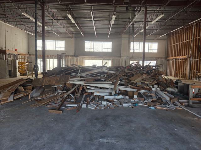 Warehouse interior stripped back, debris staged for removal