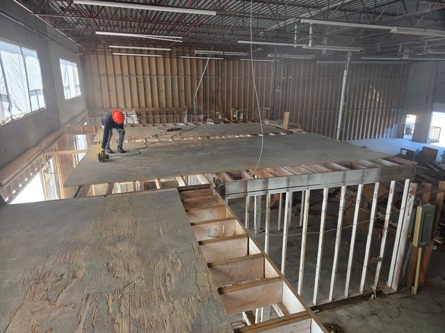 Crew member working on a mezzanine floor in a large commercial unit