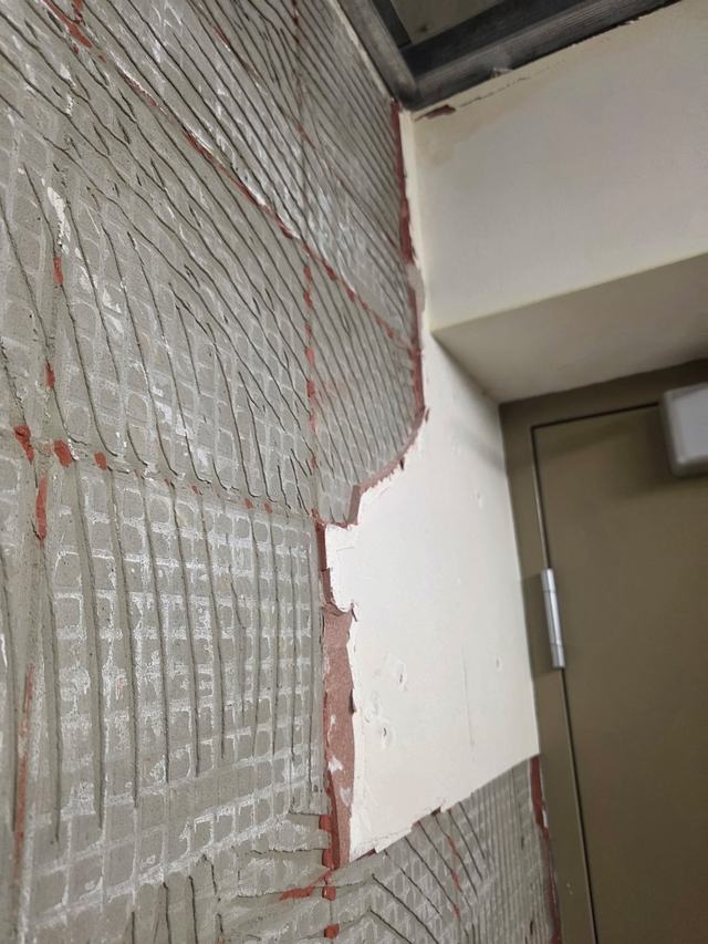 Tile and thin-set stripped from a corridor wall