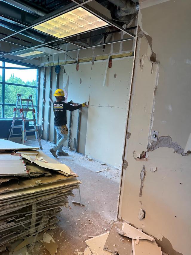 Wall board removal beside a window in an office renovation